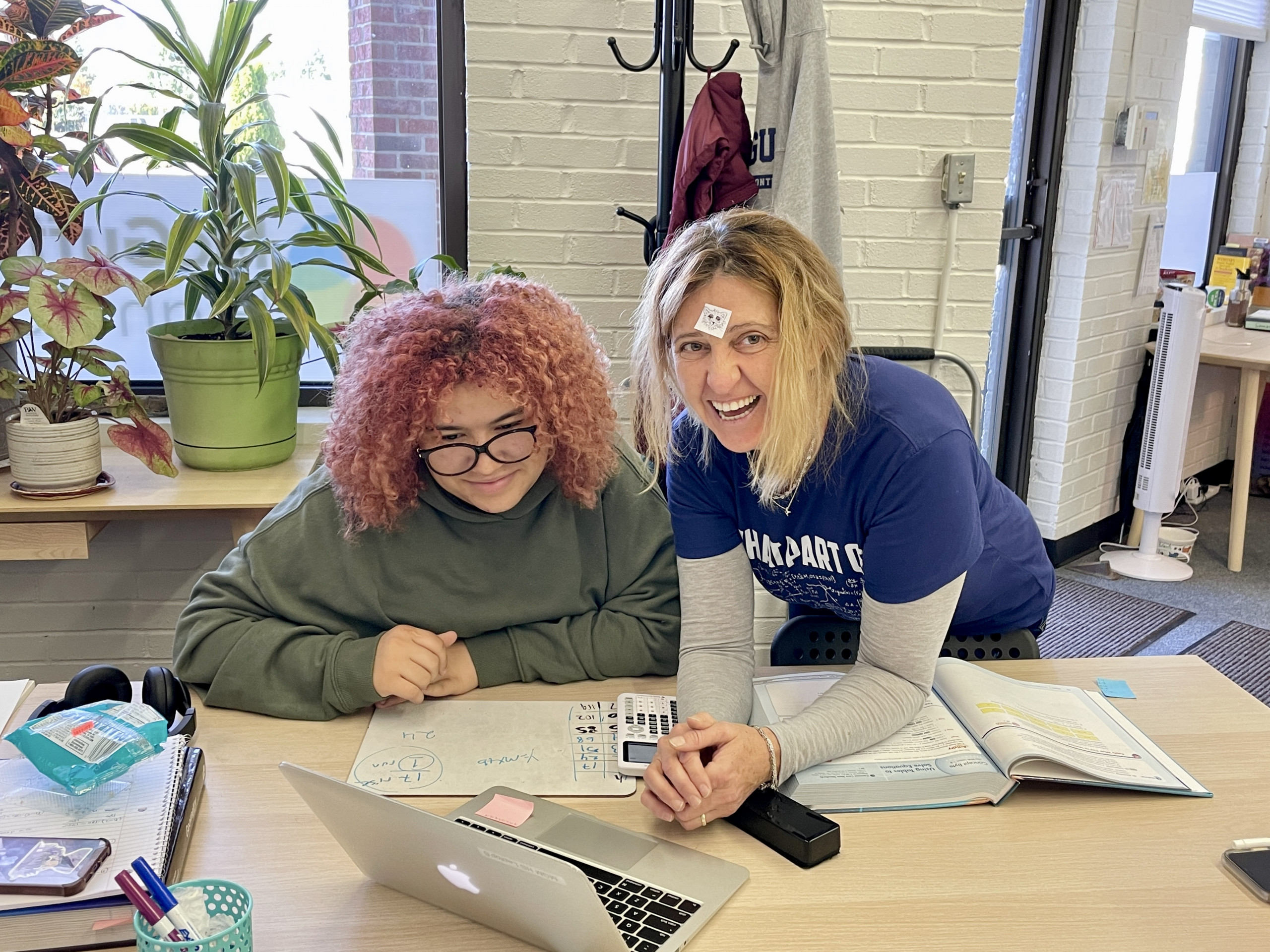 A student and teacher smiling together